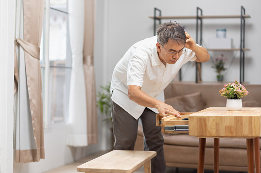 Asian older man forgetting where he put something